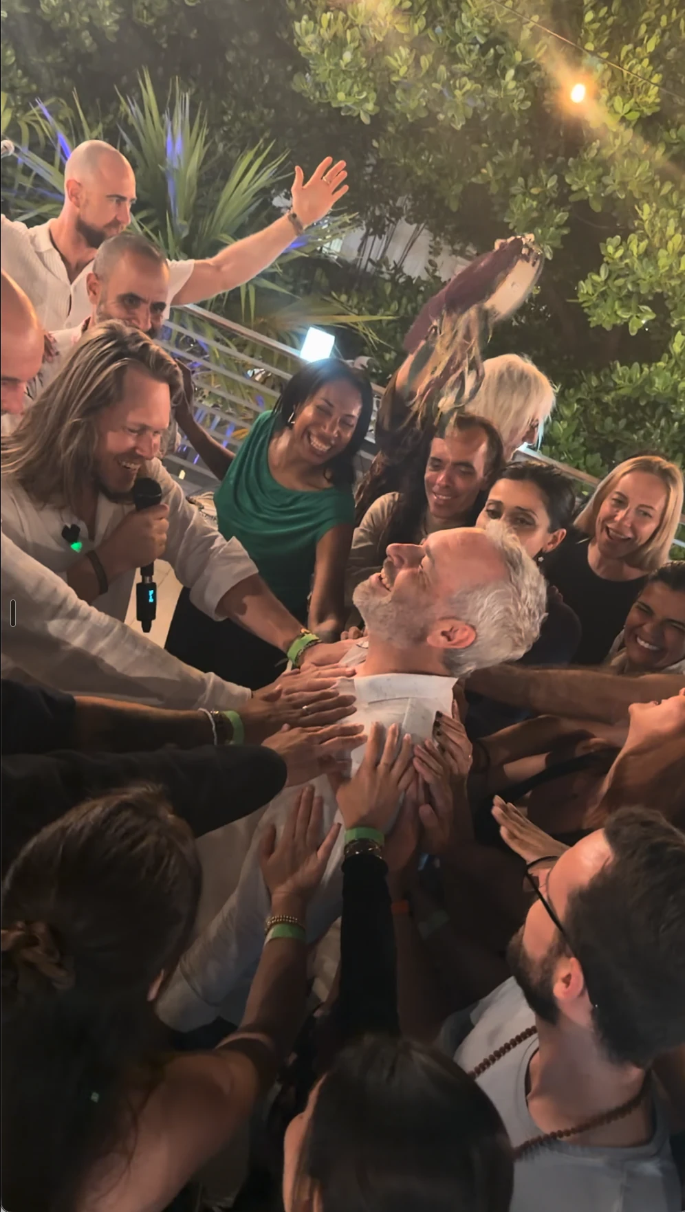 A room laying hands on one man at his birthday